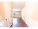 Bright foyer with hardwood floors, classic wall trim, and a view into the living area at 145 Torrey Heights Ln, Durham, NC 27703