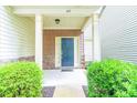 Inviting front porch with a blue door, brick accents, and well-maintained landscaping at 145 Torrey Heights Ln, Durham, NC 27703