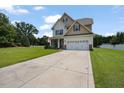 Charming two-story home featuring a manicured lawn and a convenient two-car garage, captured on a sunny day at 15 Scuppernong Ln, Lillington, NC 27546