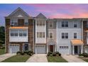 Three-story townhomes with varied facades, attached garages, and manicured front lawns create a welcoming curb appeal at 1527 Haywards Heath Ln, Apex, NC 27502