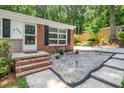 Charming front entrance with brick steps, pea gravel, and quaint seating area at 202 Crest Rd, Cary, NC 27513