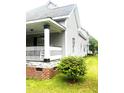 The side view of the home features classic railings, showing its architectural details and landscaping at 2113 Lee, Sanford, NC 27330
