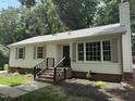 Well-maintained single-story home with white siding, brick foundation, and classic shutters on the windows at 216 Burkwood Ln, Raleigh, NC 27609