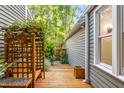 Tranquil sideyard with wooden deck, decorative trellis, and lush greenery, offering a serene outdoor space at 2205 Landings Way, Raleigh, NC 27615