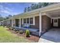 Charming brick home featuring a well-manicured lawn, covered parking, and a vibrant green door at 3009 Wellington Dr, Rocky Mount, NC 27803