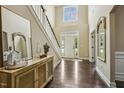 Bright foyer featuring hardwood floors, staircase, modern decor, and abundant natural light at 347 Country Mill Way, Fuquay Varina, NC 27526