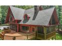 Beautiful wood home with a stone chimney and a large deck perfect for entertaining guests or relaxing outdoors at 4110 Stoneycreek Rd, Chapel Hill, NC 27514