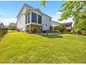 Expansive backyard featuring a covered patio with an outdoor kitchen, a dining set, and a well-maintained lawn at 633 Copper Beech Ln, Wake Forest, NC 27587