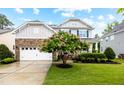 Beautiful home with a blooming tree and a stone accent garage, creating a striking and inviting exterior at 633 Copper Beech Ln, Wake Forest, NC 27587