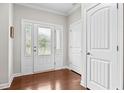 Bright foyer with hardwood floors, a decorative glass front door, and neutral walls, creating a welcoming entry at 633 Copper Beech Ln, Wake Forest, NC 27587