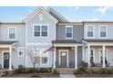 Charming gray townhome featuring a covered front porch with seating and well-kept landscaping at 728 Silo Park Dr, Wake Forest, NC 27587