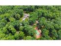 Aerial view of the property showcasing a tennis court, well-manicured grounds, and wooded surroundings at 812 Kenmore Rd, Chapel Hill, NC 27514