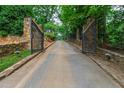 Long, gated driveway leading to a private estate surrounded by lush greenery and mature trees at 812 Kenmore Rd, Chapel Hill, NC 27514