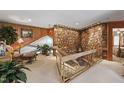 Unique foyer with a stone accent wall, glass staircase railings, and bright natural lighting at 812 Kenmore Rd, Chapel Hill, NC 27514