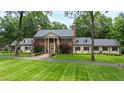 A traditionally-styled brick home offers classic curb appeal with stately columns and lush landscaping at 820 Kenmore Rd, Chapel Hill, NC 27514