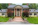 Brick home with symmetrical landscaping leading to a stately, column-lined entrance at 820 Kenmore Rd, Chapel Hill, NC 27514