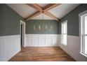 Dining room with hardwood floors, wainscoting, and vaulted ceiling with exposed beams at 913 Harrison Ridge Rd, Wake Forest, NC 27587