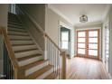 Inviting entryway with hardwood floors, modern light fixture, and staircase leading to upper level at 913 Harrison Ridge Rd, Wake Forest, NC 27587