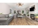 Cozy living room with fireplace, light gray sofa, wood flooring, and lots of natural light at 1003 Burnt Hickory Ct, Apex, NC 27502