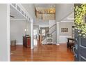 Bright foyer featuring gleaming hardwood floors, a staircase, and an open floor plan at 107 Trackimire Ln, Apex, NC 27539