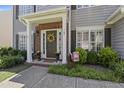 Charming entryway with a decorated front door, brick accents, and manicured landscaping at 107 Trackimire Ln, Apex, NC 27539