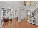 Spacious living room with hardwood floors, a fireplace, and custom built-in shelving at 107 Trackimire Ln, Apex, NC 27539