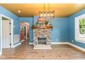 Spacious living room with stone fireplace, hardwood floors, bright lighting and access to other rooms at 109 St Marys St, Garner, NC 27529
