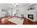 Inviting living room boasting hardwood floors, fireplace, and large sunlit windows at 10941 Pendragon Pl, Raleigh, NC 27614