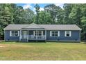 Charming blue single-story home with a covered front porch and well-maintained lawn at 1118 Oakridge Duncan Rd, Fuquay Varina, NC 27526
