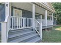 Inviting front porch with white railing, gray painted steps, and a decorative wreath on the front door at 1118 Oakridge Duncan Rd, Fuquay Varina, NC 27526
