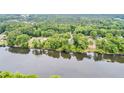 Aerial view of a river winding through a wooded area with scattered homes at 1164 Keith Hills Rd, Lillington, NC 27546