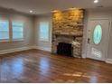 Bright living room featuring a stone fireplace and hardwood floors at 119 W Vernon Ave, Wake Forest, NC 27587
