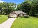 Beautifully landscaped brick home with a long driveway and mature trees at 143 Cedarwood Dr, Henderson, NC 27536