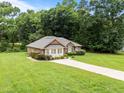 Well-maintained brick home with a lush green lawn and tidy landscaping at 143 Cedarwood Dr, Henderson, NC 27536