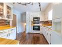 Bright kitchen with white cabinets, wood countertops, and wood backsplash at 1500 Prisma Ct, Raleigh, NC 27612