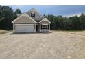 Charming two-story home featuring a gray-shingled facade, attached garage, and well-lit window under a blue sky at 157 Mildred Pl, Broadway, NC 27505