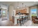 Open kitchen with a breakfast bar, modern pendant lighting, stainless appliances, and hardwood flooring at 157 Mildred Pl, Broadway, NC 27505