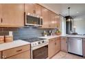 Modern kitchen featuring stainless steel appliances, light wood cabinetry, and a stylish gray backsplash at 157 Mildred Pl, Broadway, NC 27505