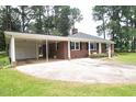 Spacious driveway and carport of a brick home, providing ample parking and covered space at 205 N Augusta Ave, Benson, NC 27504