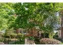 Beautiful brick townhome with lush landscaping and mature trees surrounding the property at 218 W Barbee Chapel Rd, Chapel Hill, NC 27517