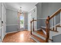 Foyer with hardwood floors, staircase, chandelier, and natural light streaming through the window at 2216 Hoskins Rd, Burlington, NC 27215