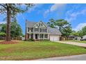 Charming two-story home with an attached garage, inviting front porch, and well-manicured lawn at 248 Robin Loop, Dunn, NC 28334