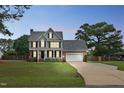 Charming two-story home with an attached garage, inviting front porch, and manicured lawn at dusk at 248 Robin Loop, Dunn, NC 28334