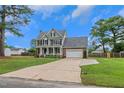 Charming two-story home with an attached garage, inviting front porch, and long driveway at 248 Robin Loop, Dunn, NC 28334