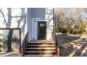 Inviting front entrance with wooden steps, black railings, and a modern black door at 2513 Rochelle St, Durham, NC 27703
