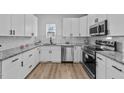 Modern kitchen featuring white cabinetry, granite countertops, and stainless steel appliances at 2513 Rochelle St, Durham, NC 27703
