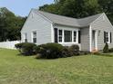 A charming residence boasting manicured lawns, decorative shrubbery, and stylish gray and white siding at 306 W Canary St, Dunn, NC 28334