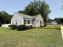 Inviting home with manicured lawn, gray siding, black shutters, and decorative landscaping at 306 W Canary St, Dunn, NC 28334