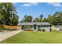 Landscaped home featuring a carport and driveway, surrounded by mature trees at 4021 Chaucer Dr, Durham, NC 27705