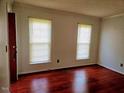 This bedroom features hardwood floors and two windows for natural light at 5301 Peacenest Dr, Raleigh, NC 27610